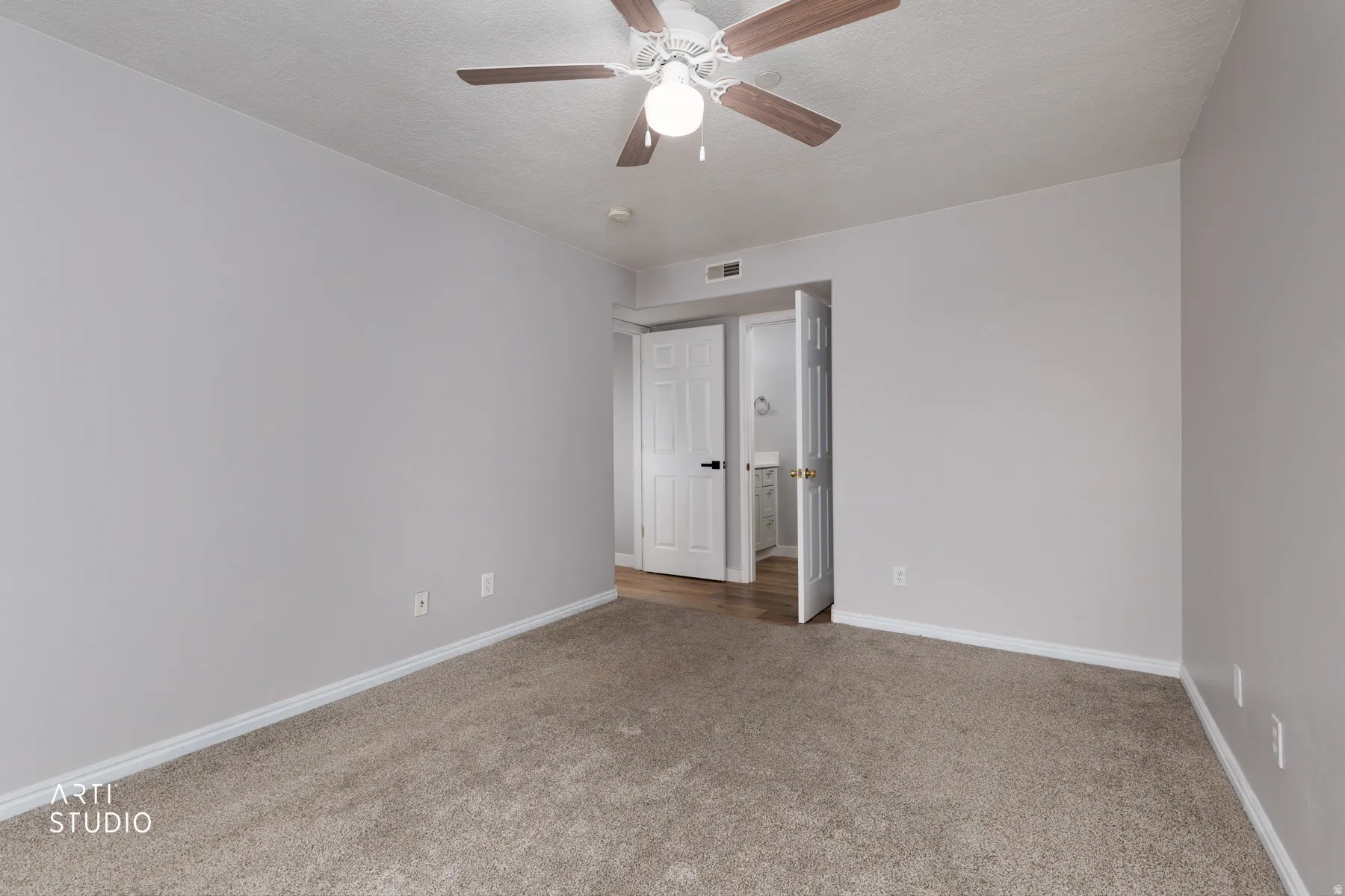 Empty room with light carpet and a ceiling fan