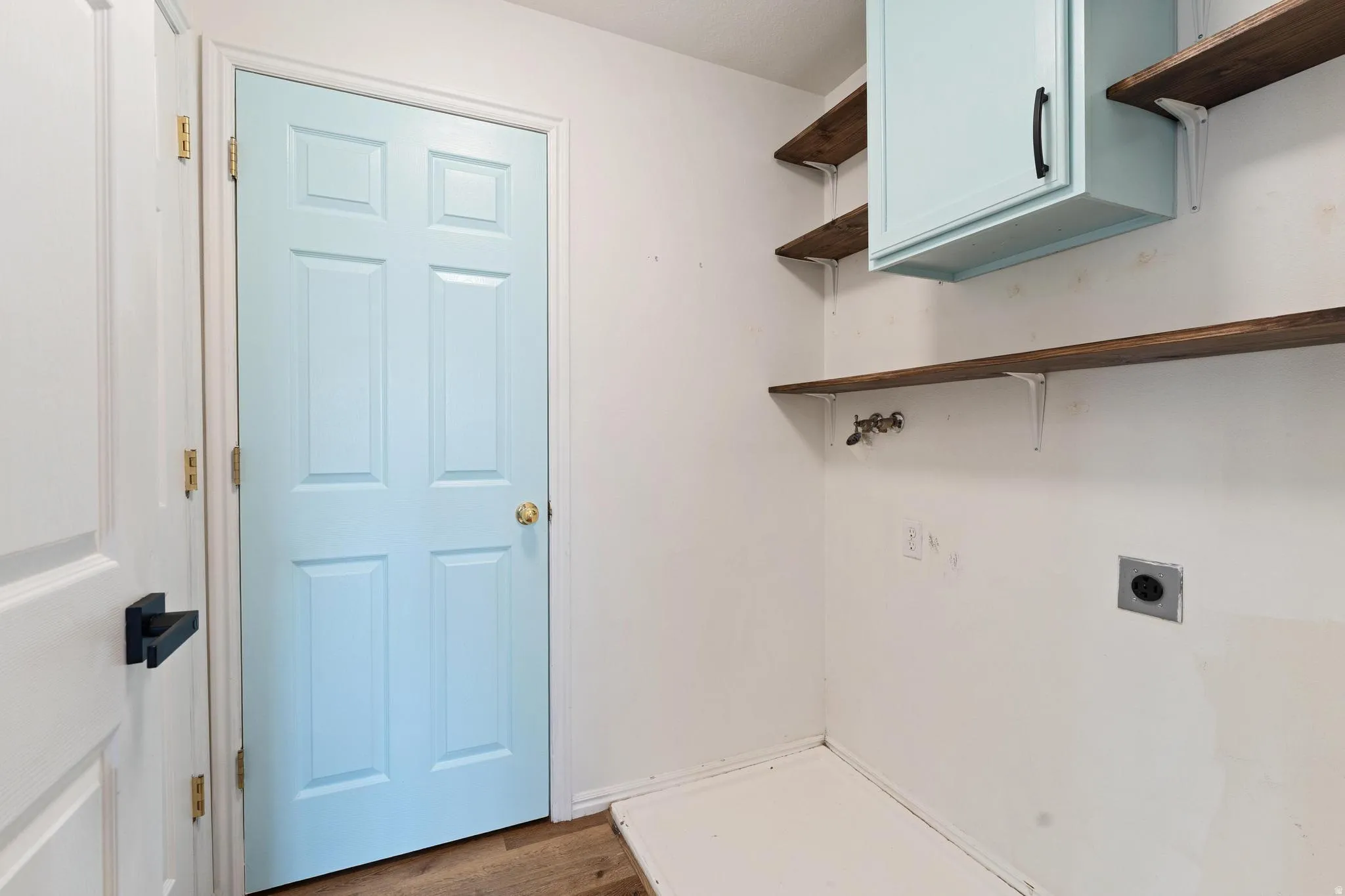 Laundry area featuring cabinet space, dark wood finished floors, electric dryer hookup, and washer hookup