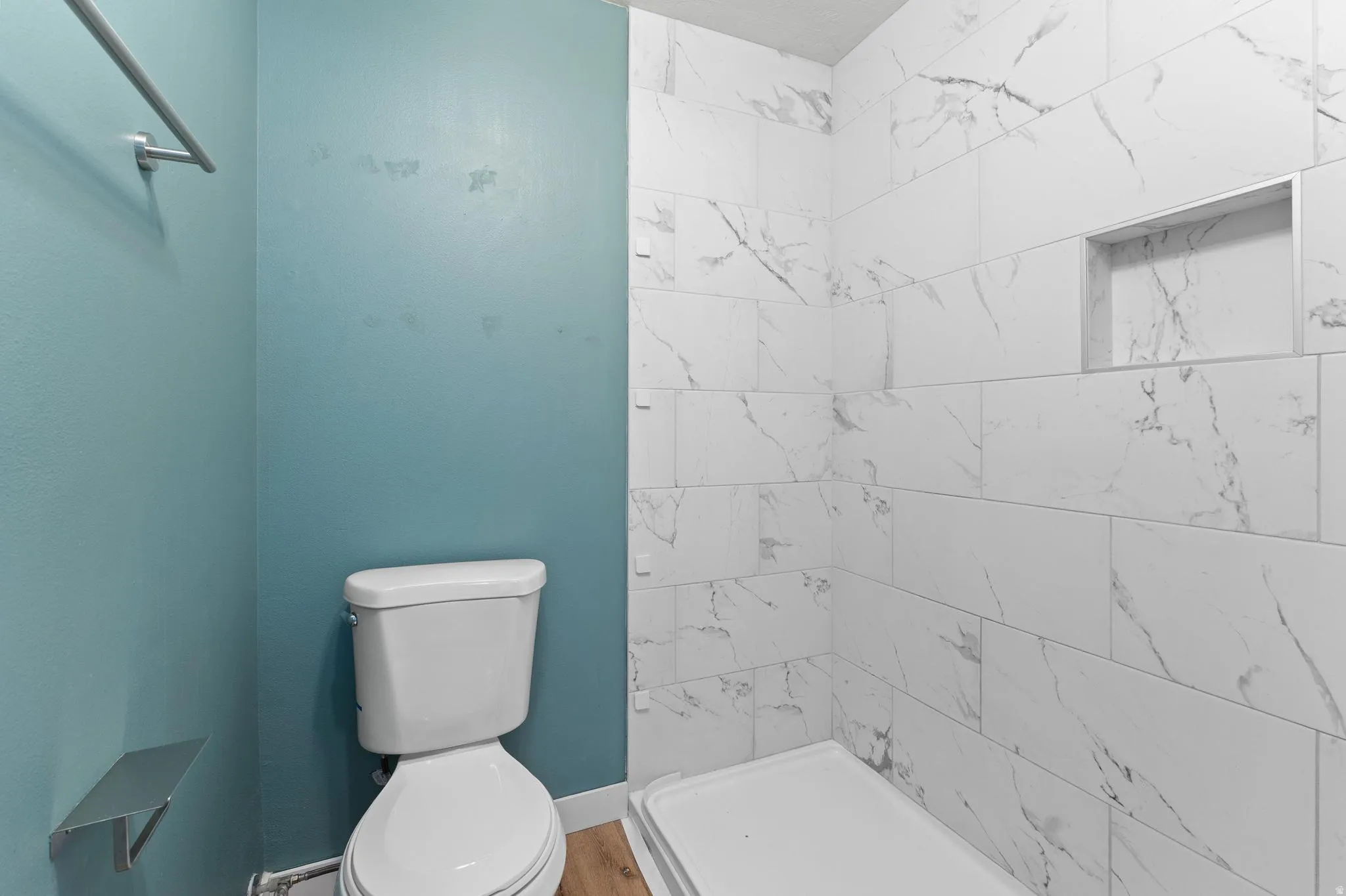 Full bathroom with a stall shower and baseboard heating