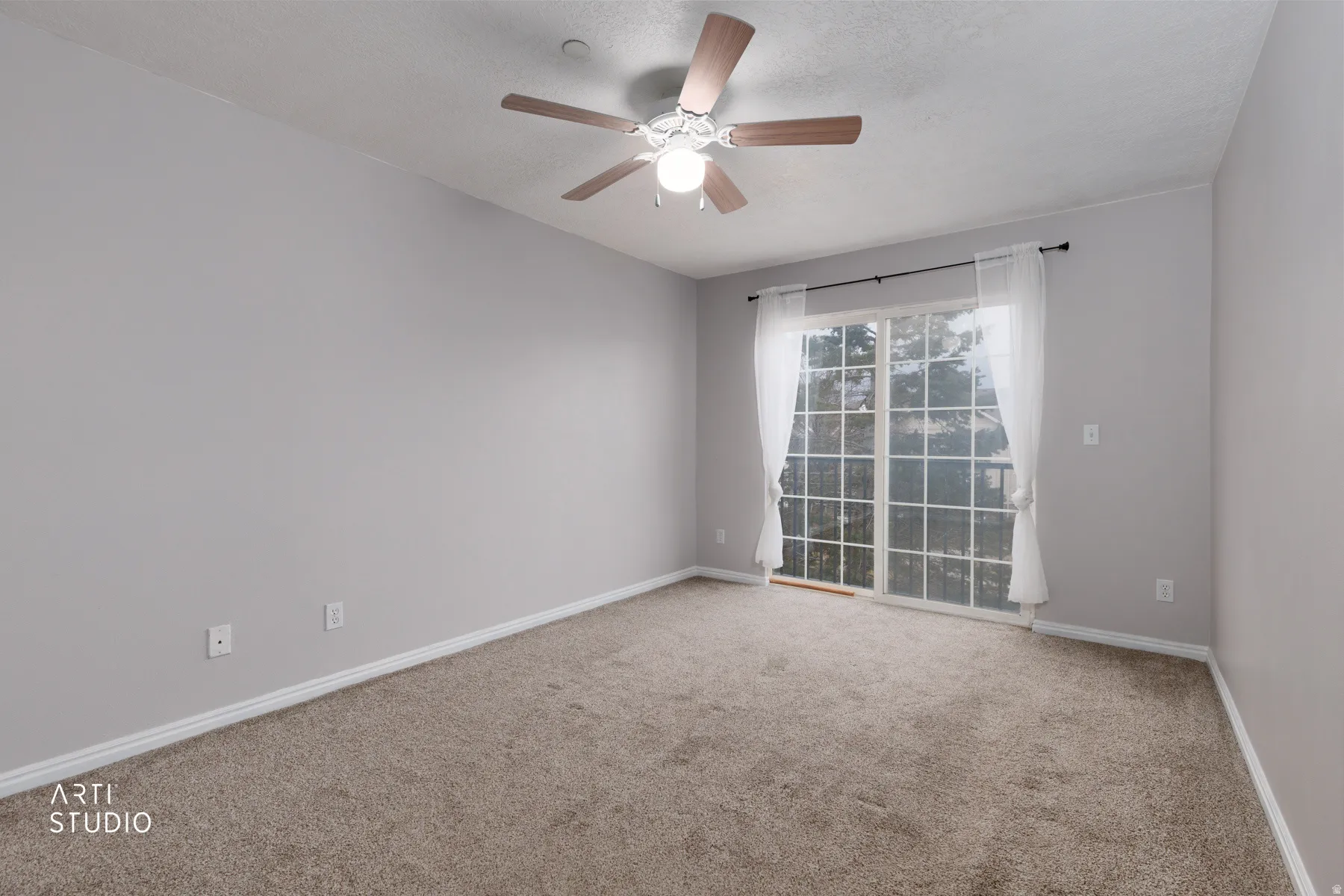 Empty room featuring carpet floors, ceiling fan, and a textured ceiling