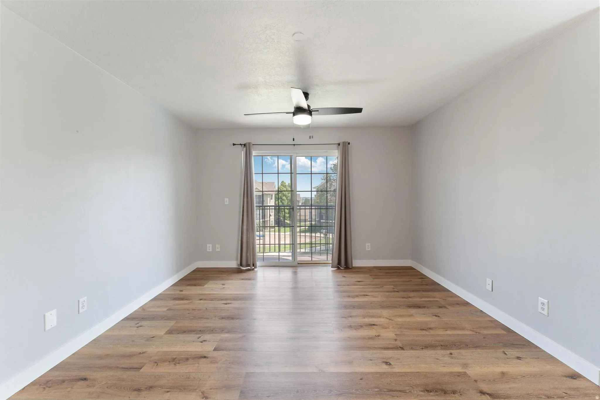 Empty room with light wood finished floors and ceiling fan