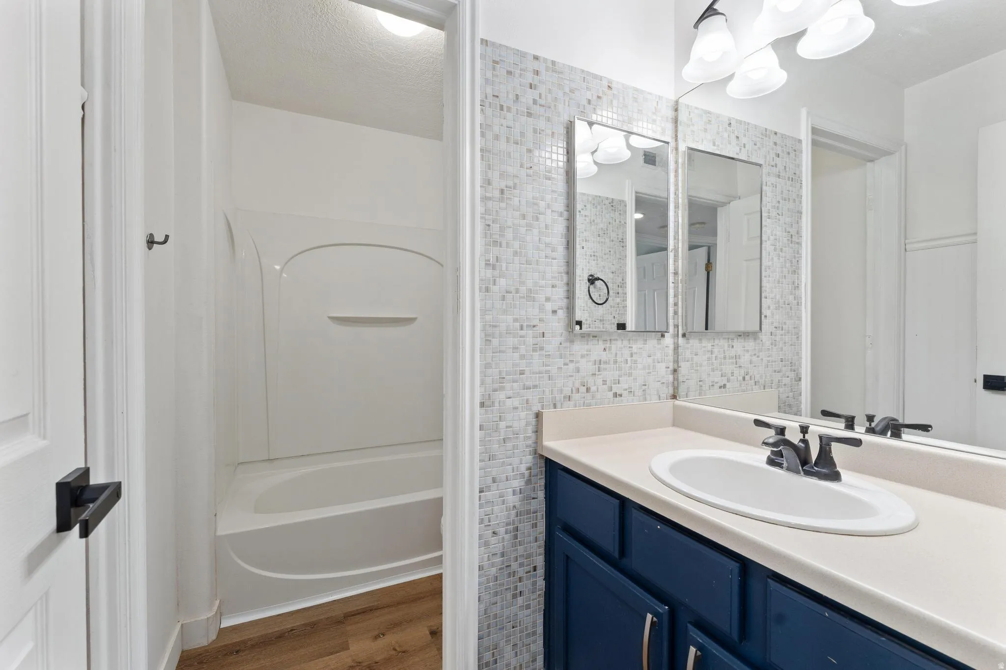 Full bathroom with vanity, dark wood finished floors, and bathtub / shower combination