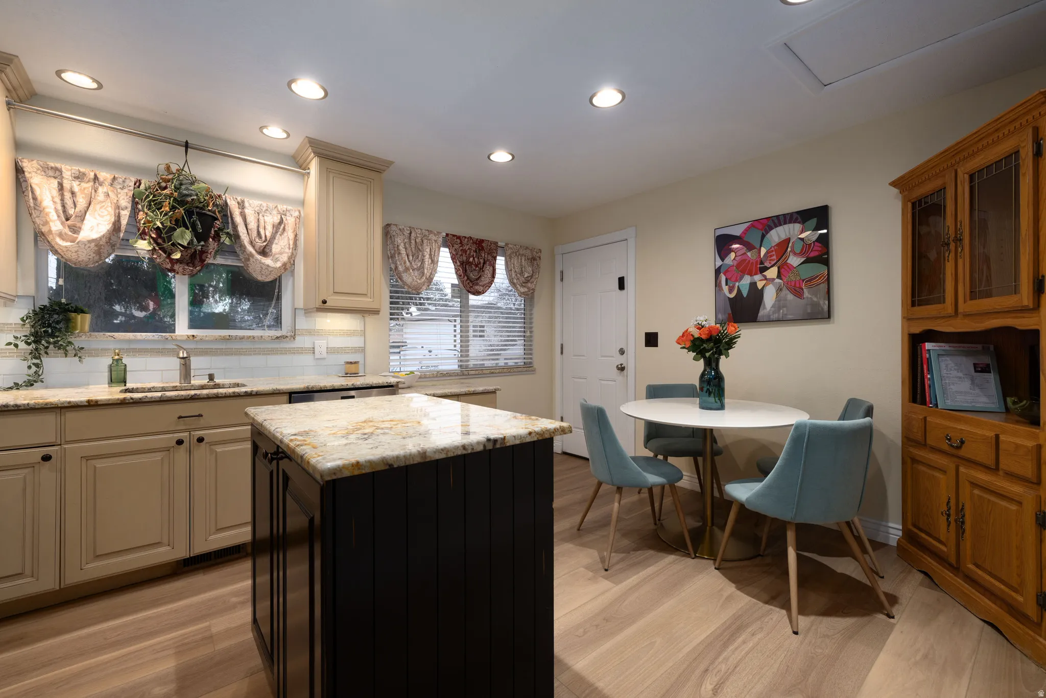 Kitchen featuring backsplash, cream cabinets, a kitchen island, new light LVP wood-style flooring, and recessed lighting
