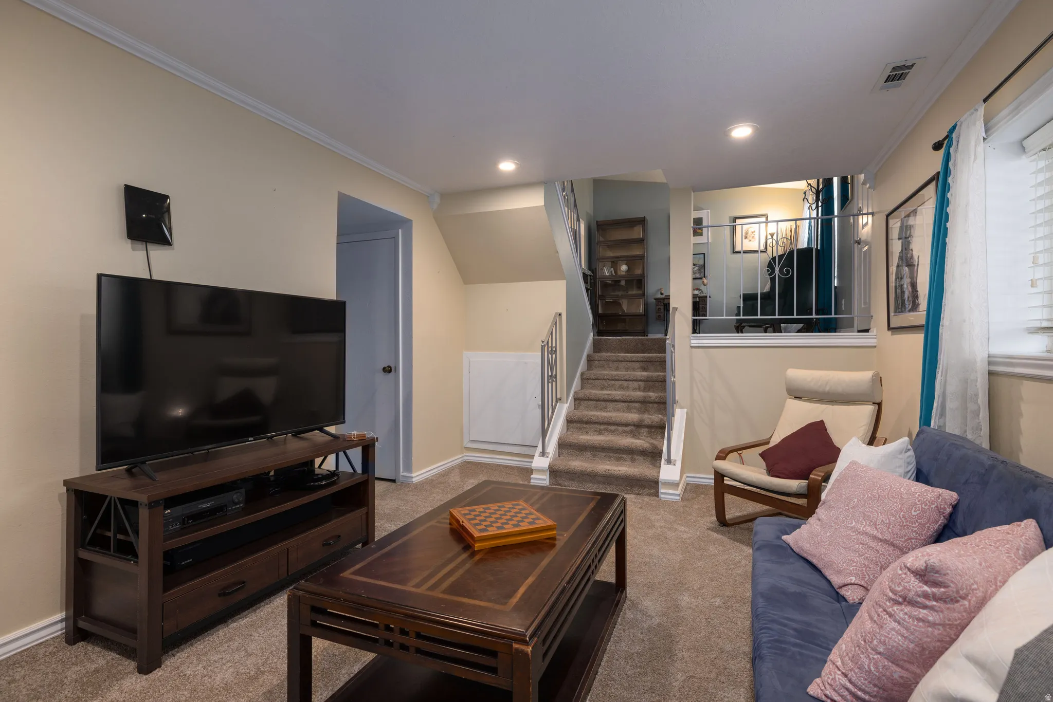 Newly carpeted living room with crown molding and recessed lighting