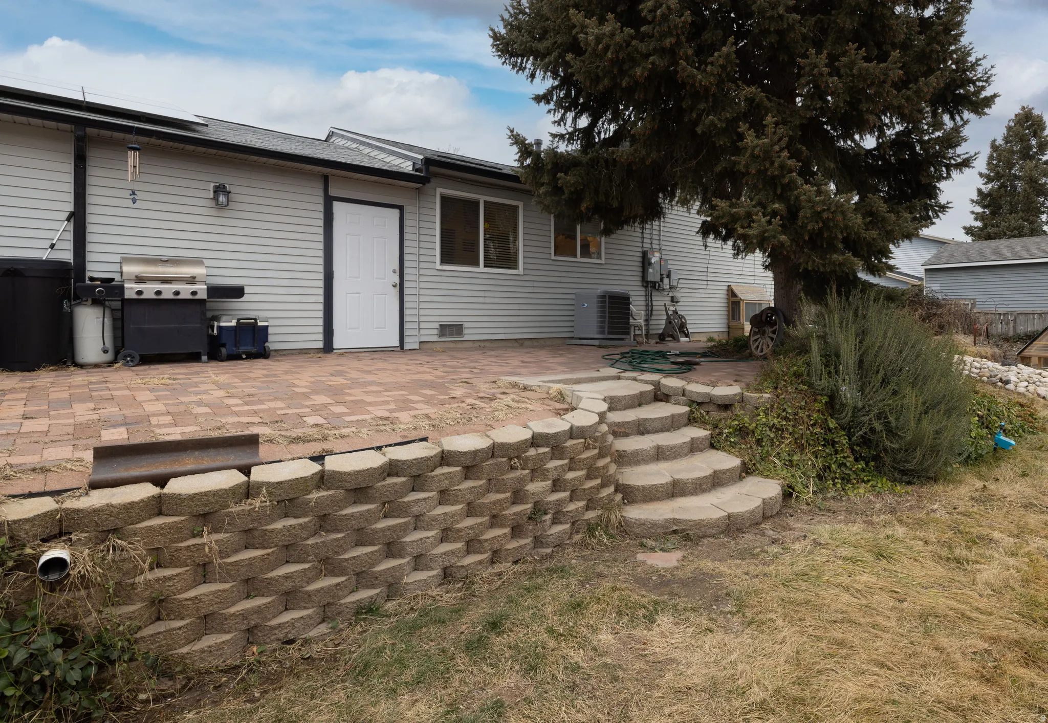Back of house featuring beautiful patio pavers and roof mounted solar panels
