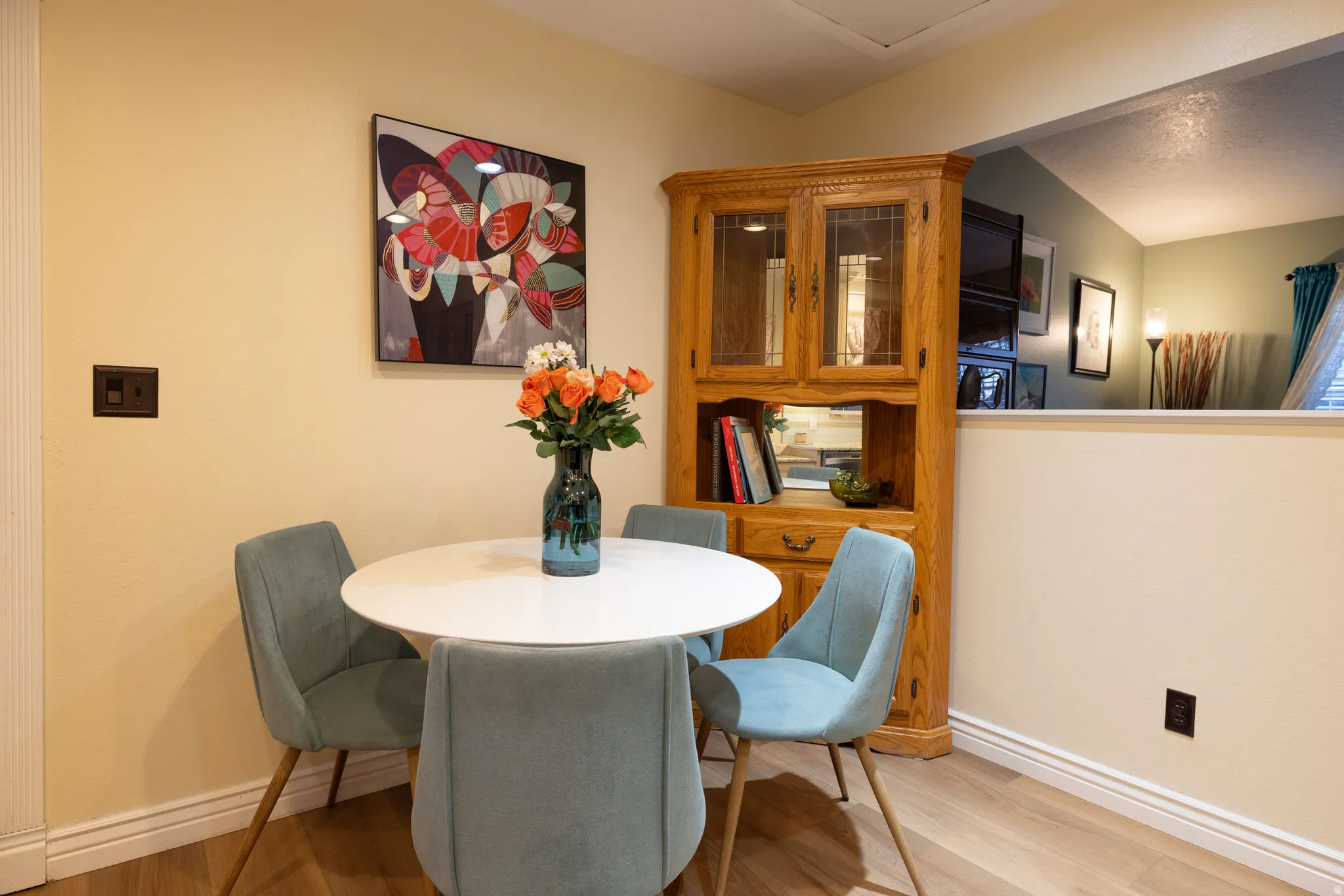 Dining space with new LVP light wood-style floors and lofted ceiling