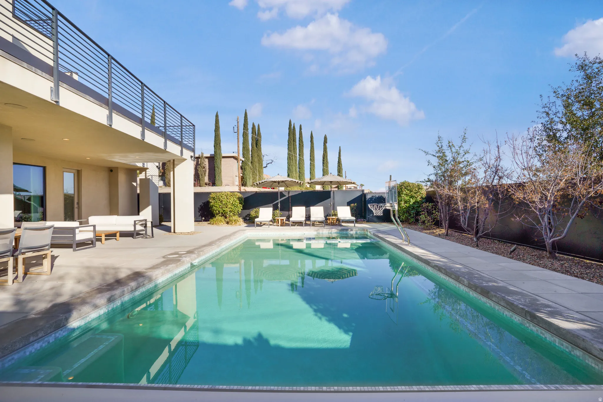 View of pool featuring patio surround and a fenced backyard