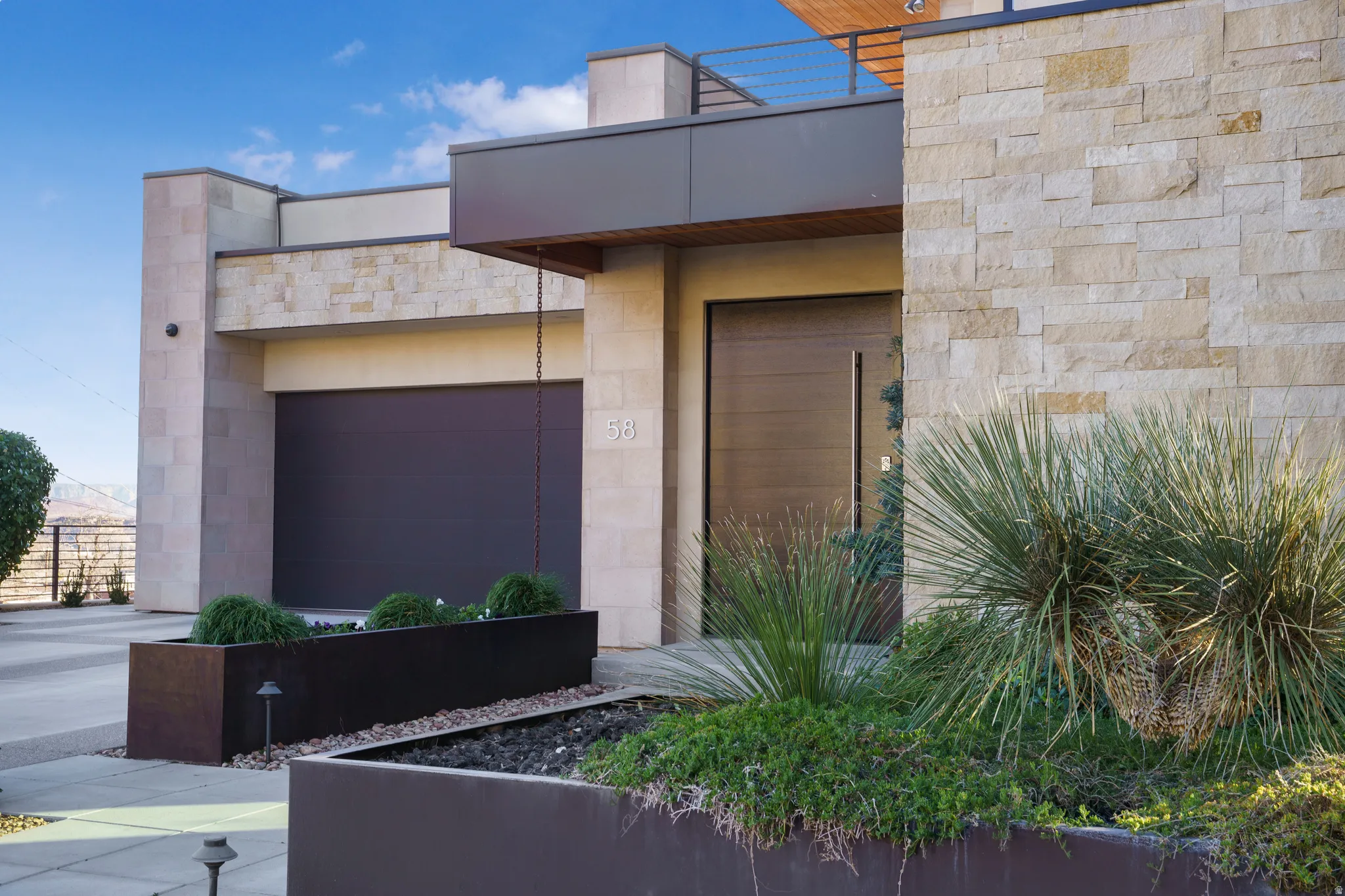 View of exterior entry with stone siding and a garage