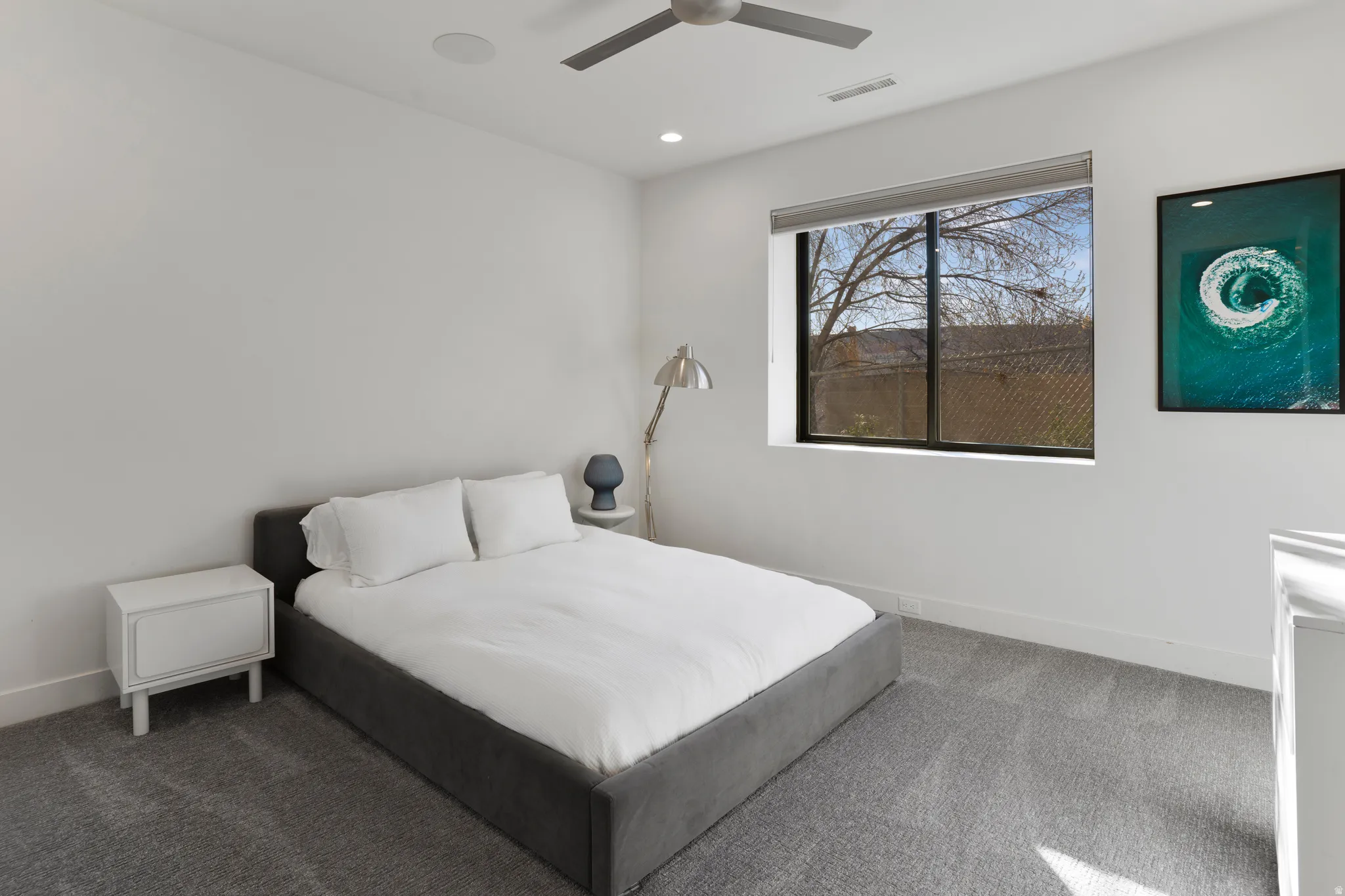 Carpeted bedroom featuring ceiling fan and recessed lighting