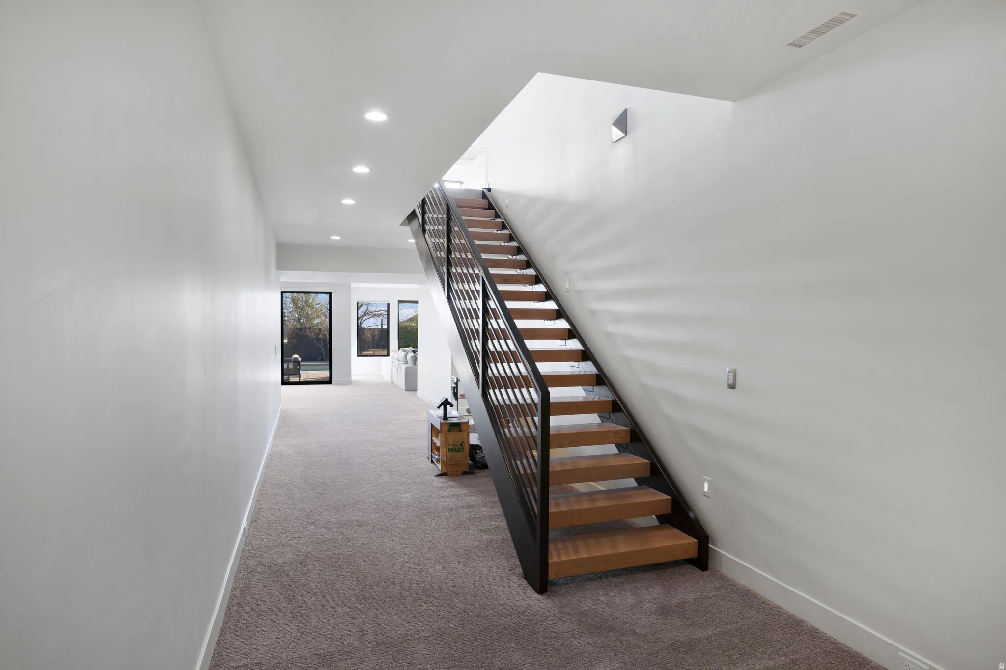 Staircase with recessed lighting and carpet floors
