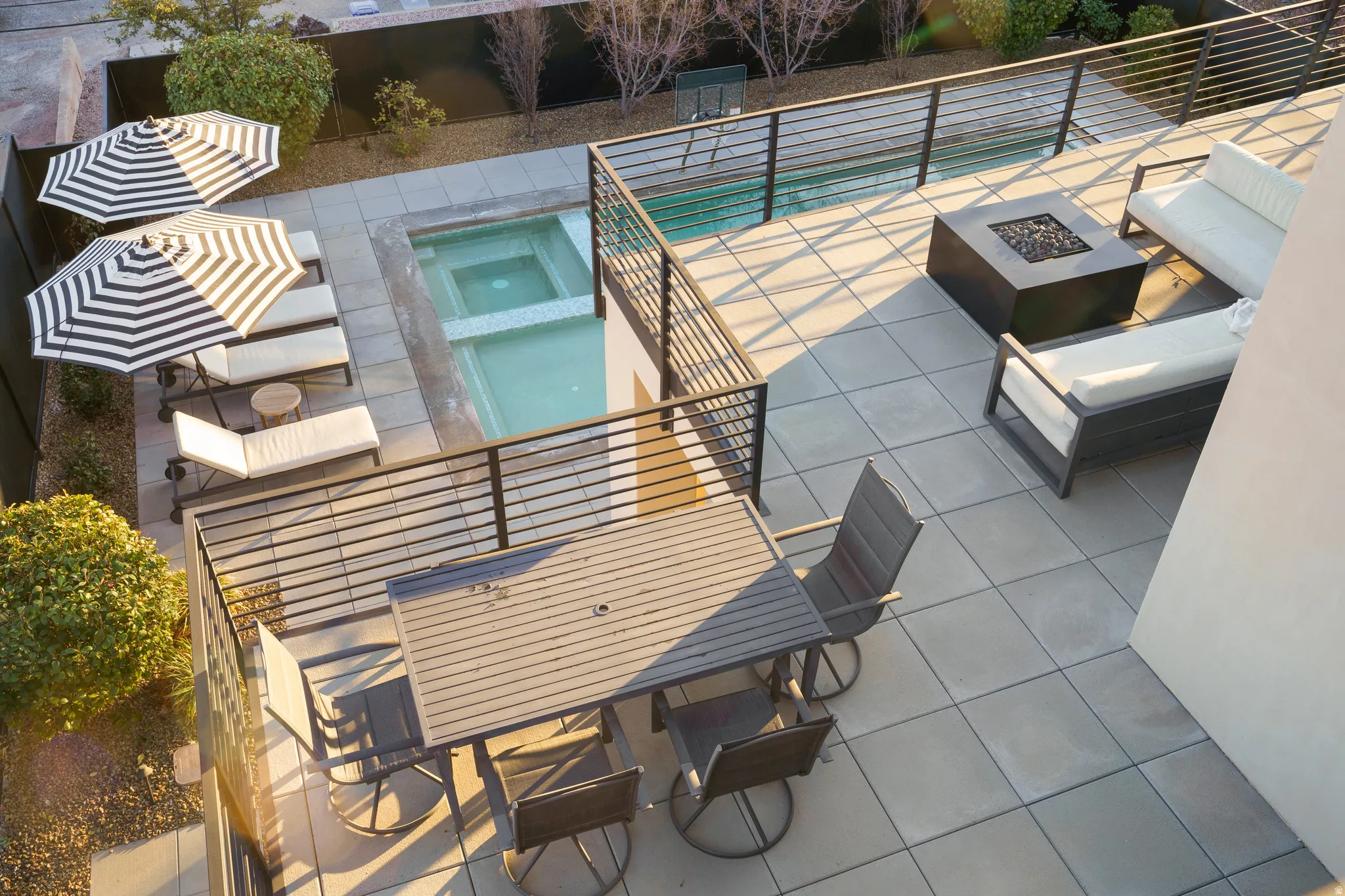 View of patio featuring a fire pit, outdoor dining area, and a pool with connected hot tub