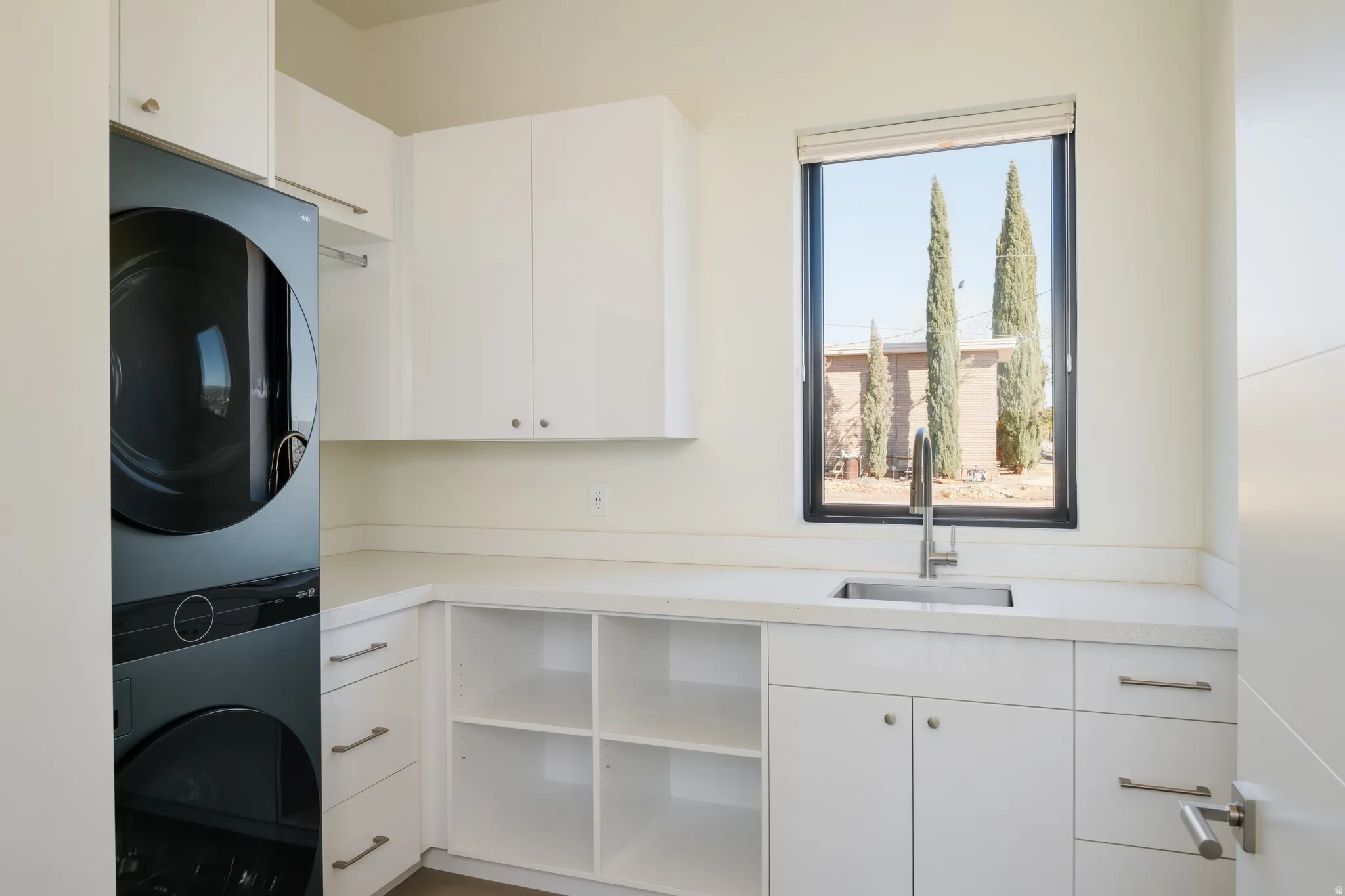 Laundry room featuring cabinet space and stacked washer / drying machine