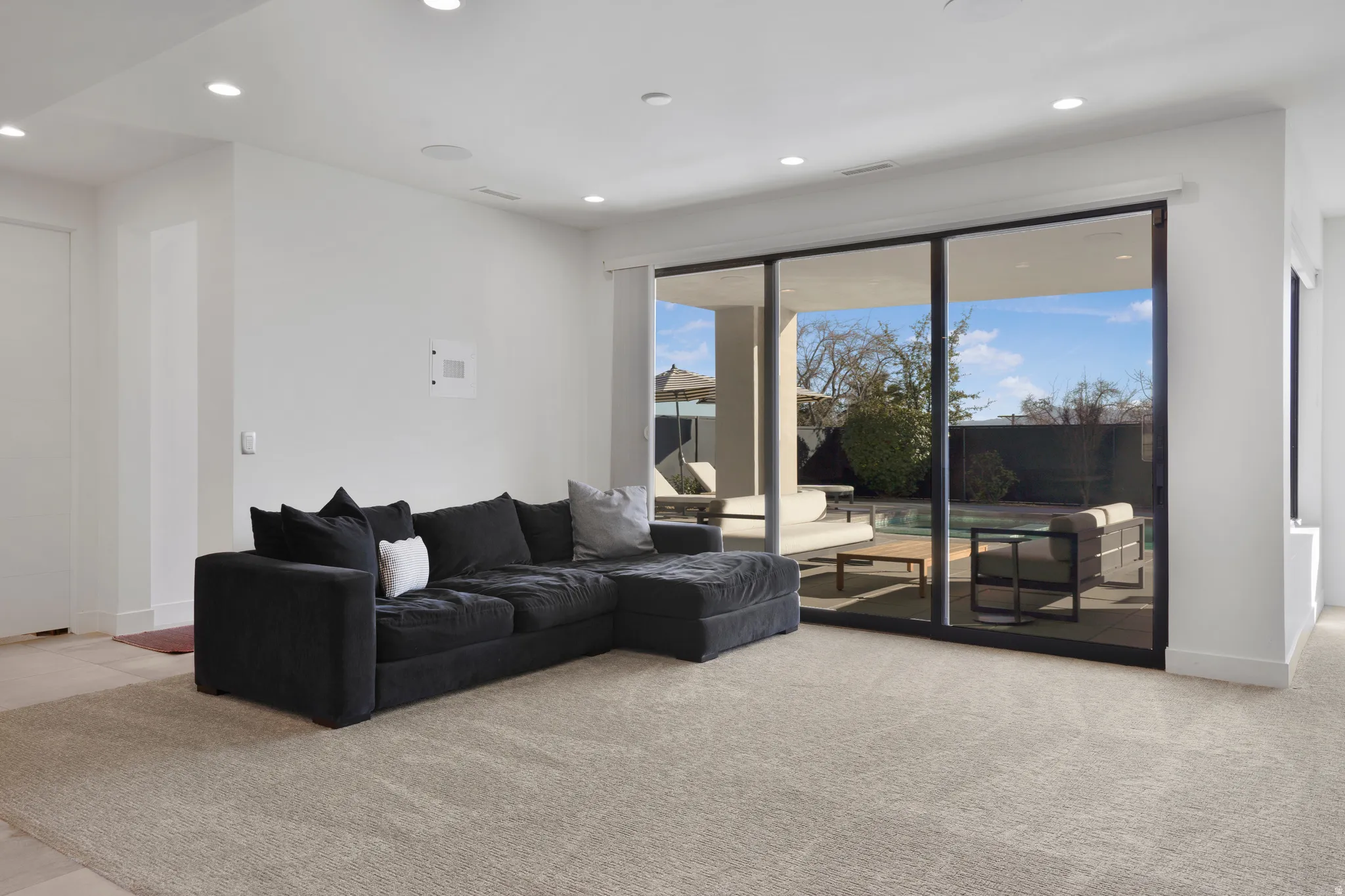 Living area with recessed lighting and light colored carpet