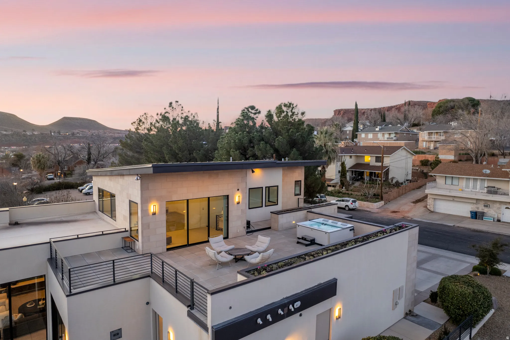 Back of house at dusk with concrete block siding, a mountain view, and a patio area