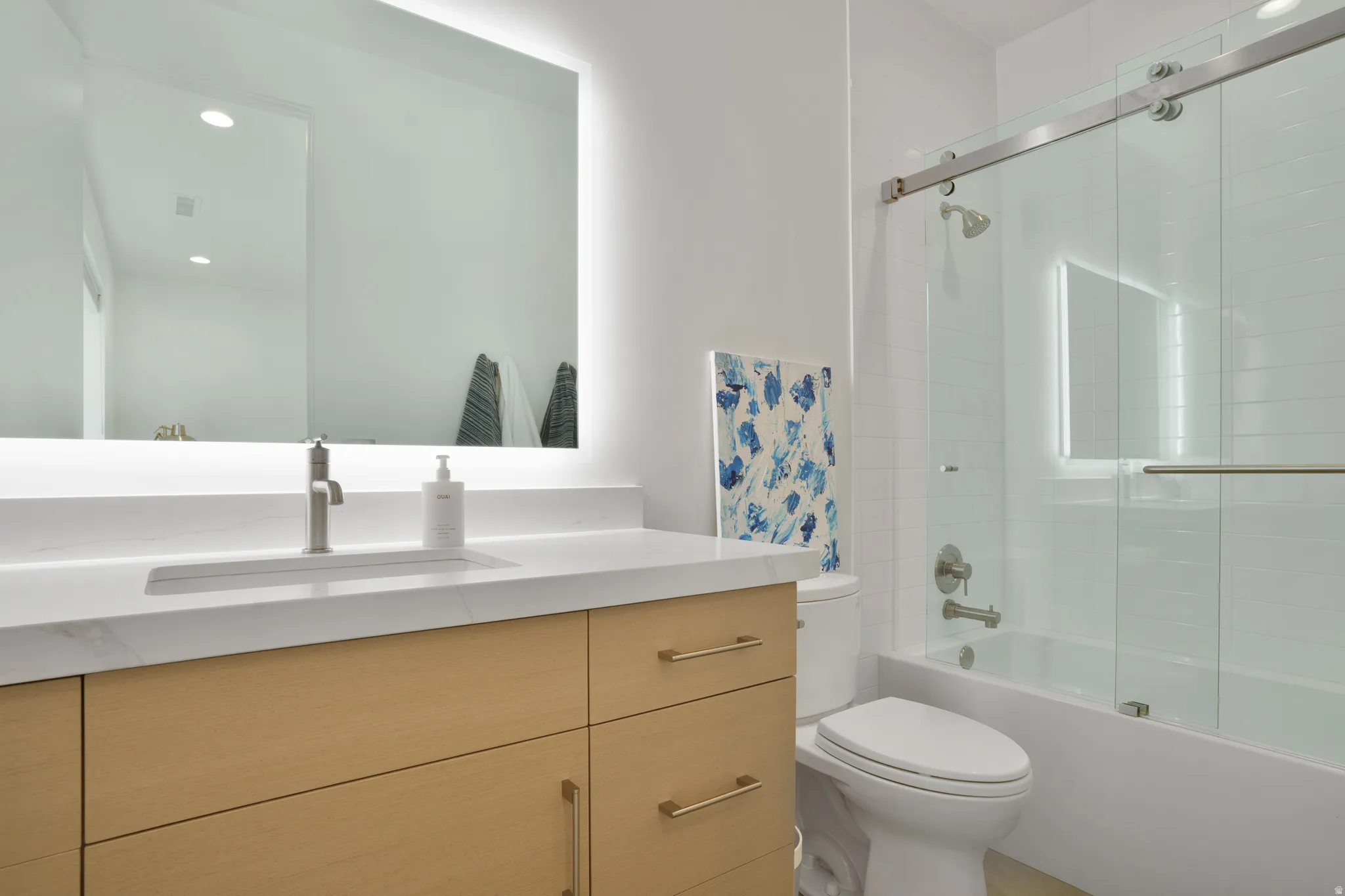 Bathroom featuring vanity, shower / bath combination with glass door, and recessed lighting