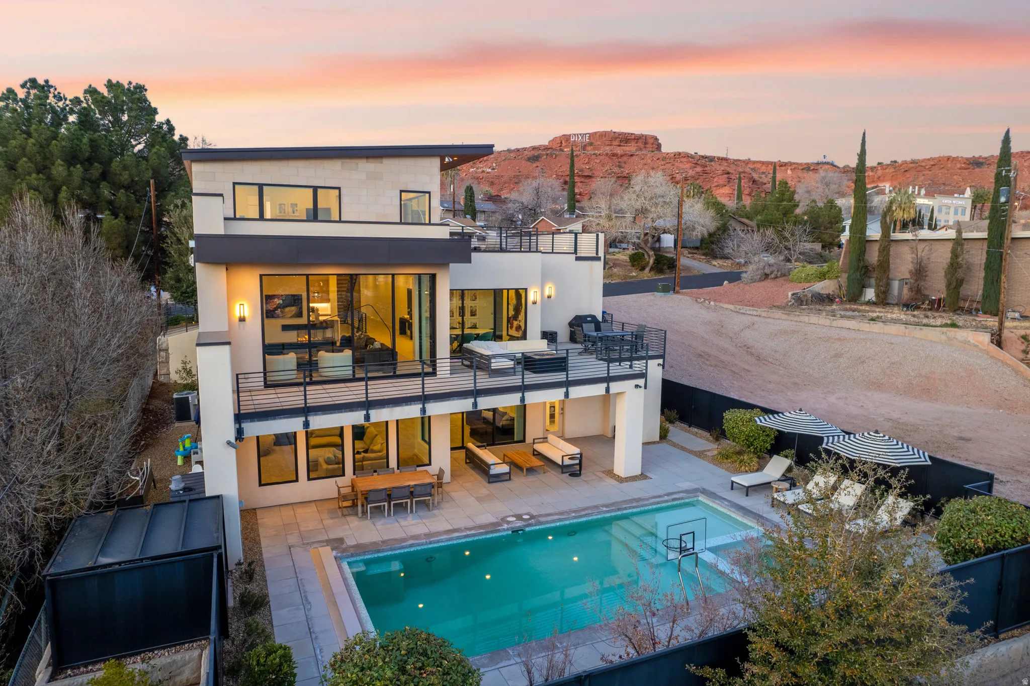Rear view of property with stucco siding, outdoor dining area, an outdoor pool, a patio, and a mountain view
