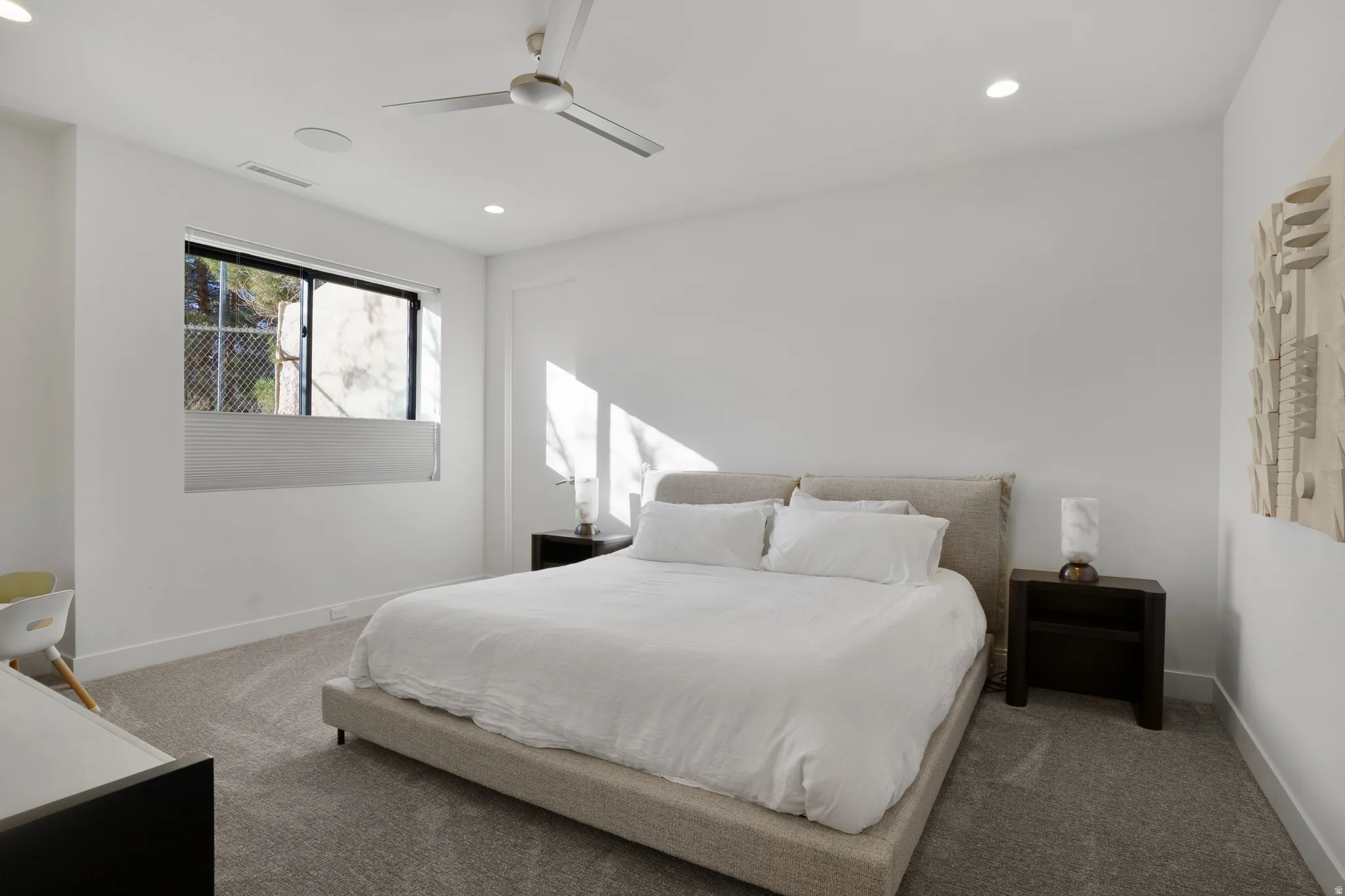 Carpeted bedroom with a ceiling fan and recessed lighting