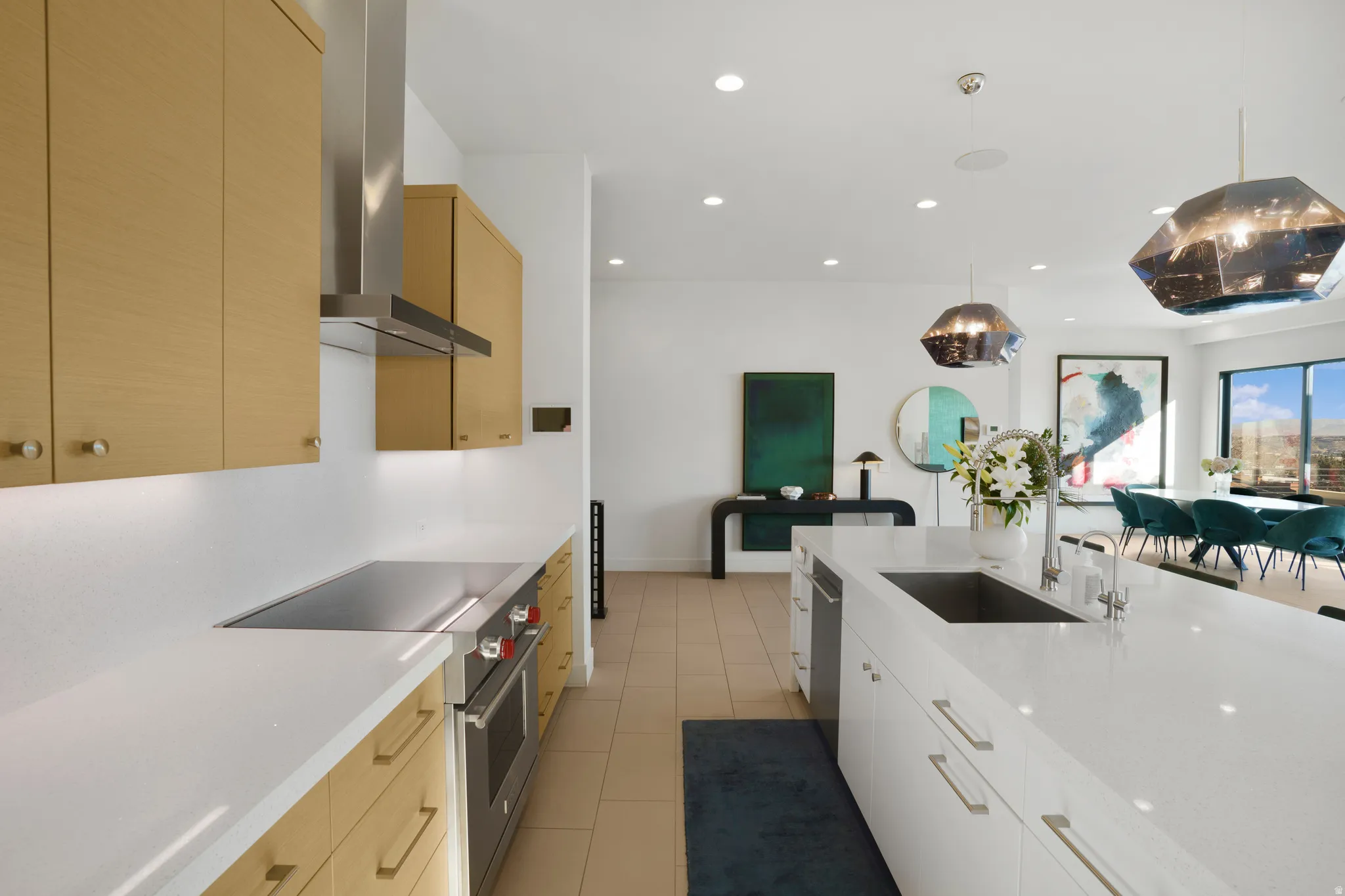 Kitchen with stainless steel appliances, hanging light fixtures, light stone countertops, and light wood finish cabinetry