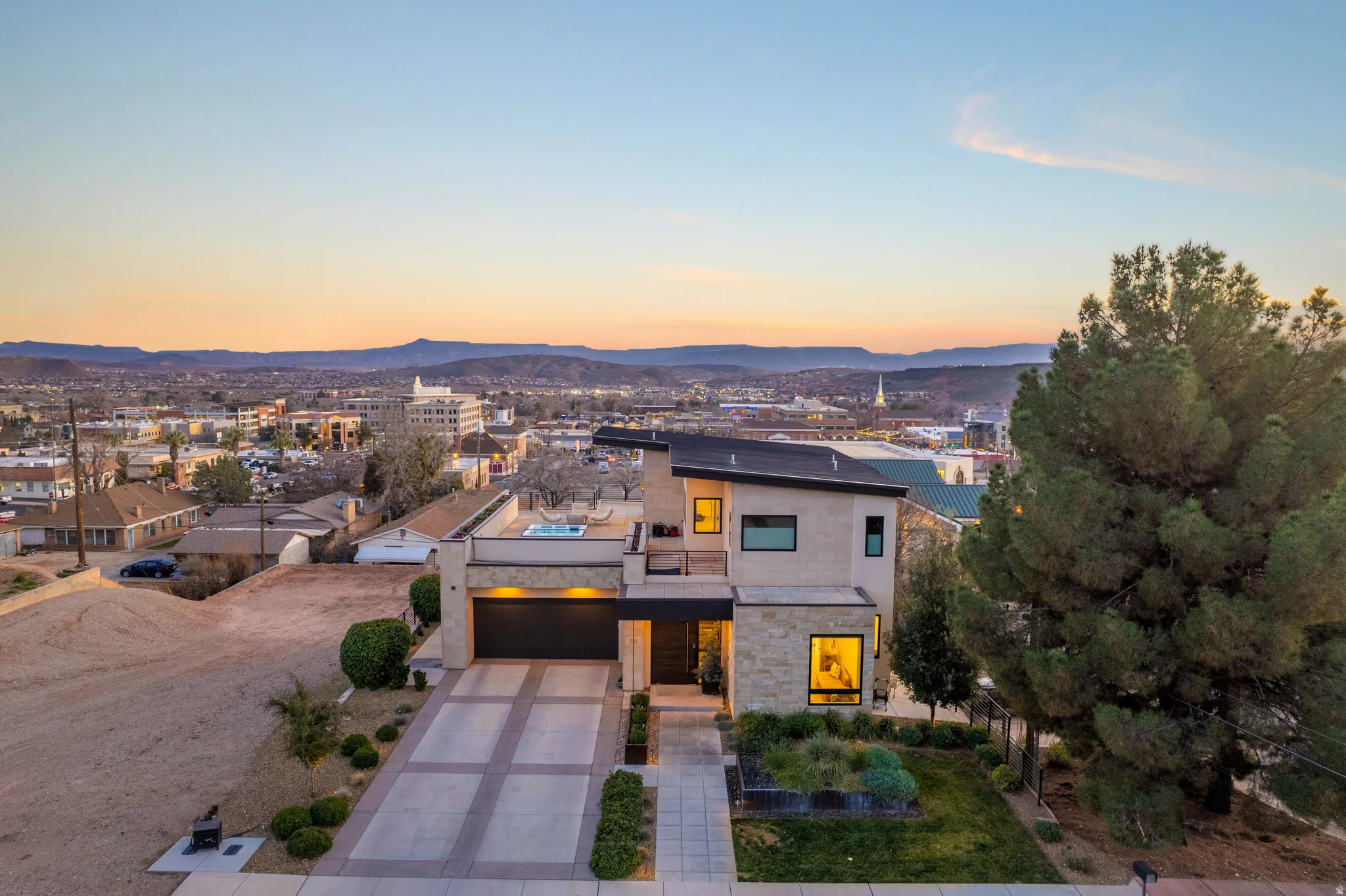 Contemporary home with driveway, stone siding, a mountain view, and stucco siding