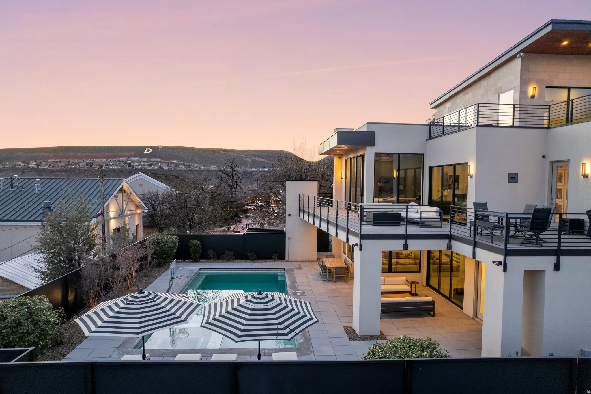 Pool at dusk with a patio and outdoor dining area