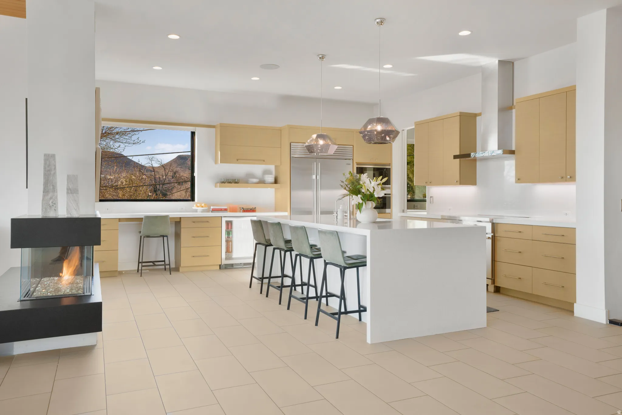 Kitchen with a kitchen bar, built in refrigerator, hanging light fixtures, open shelves, and modern cabinets