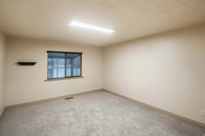 Carpeted spare room with baseboards and a textured ceiling