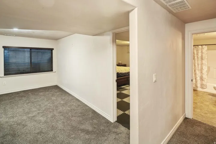 Corridor featuring dark carpet and baseboards