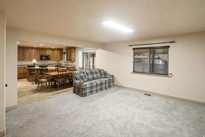 Living room with light colored carpet, a textured ceiling, healthy amount of natural light, and recessed lighting