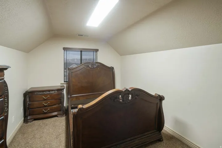 Bedroom with a textured ceiling and carpet flooring