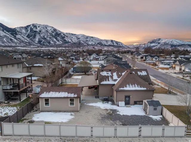 Snowy aerial view with a mountain view and a residential view