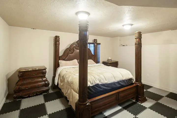 Bedroom with a textured ceiling and baseboards