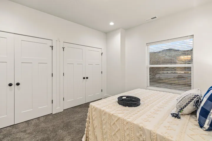 Bedroom featuring dark colored carpet, two closets, and recessed lighting