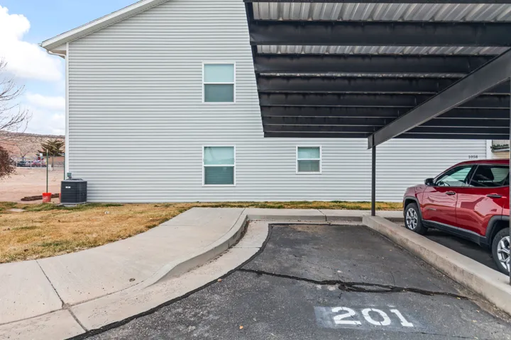 View of side of home featuring covered and uncovered parking and a cooling unit