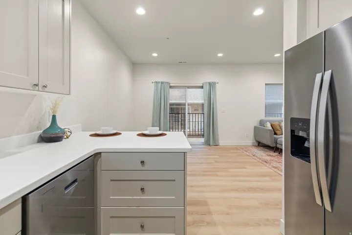 Kitchen with stainless steel appliances, light wood-type flooring, recessed lighting, light countertops, and a peninsula