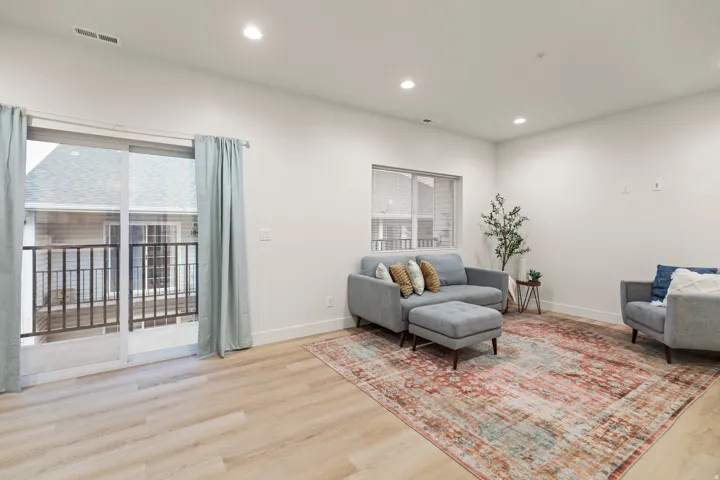 Living area with light wood finished floors and recessed lighting