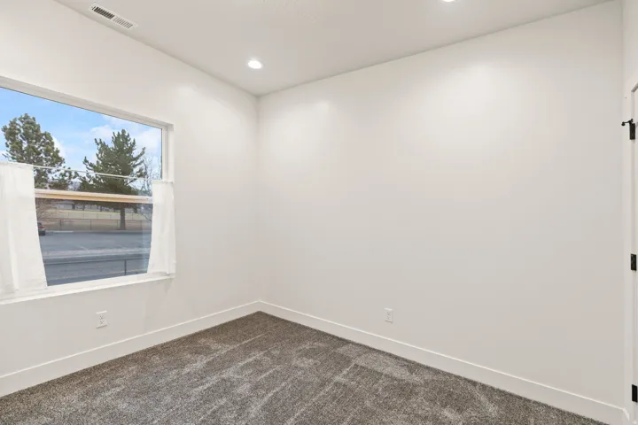Spare room with dark carpet and recessed lighting