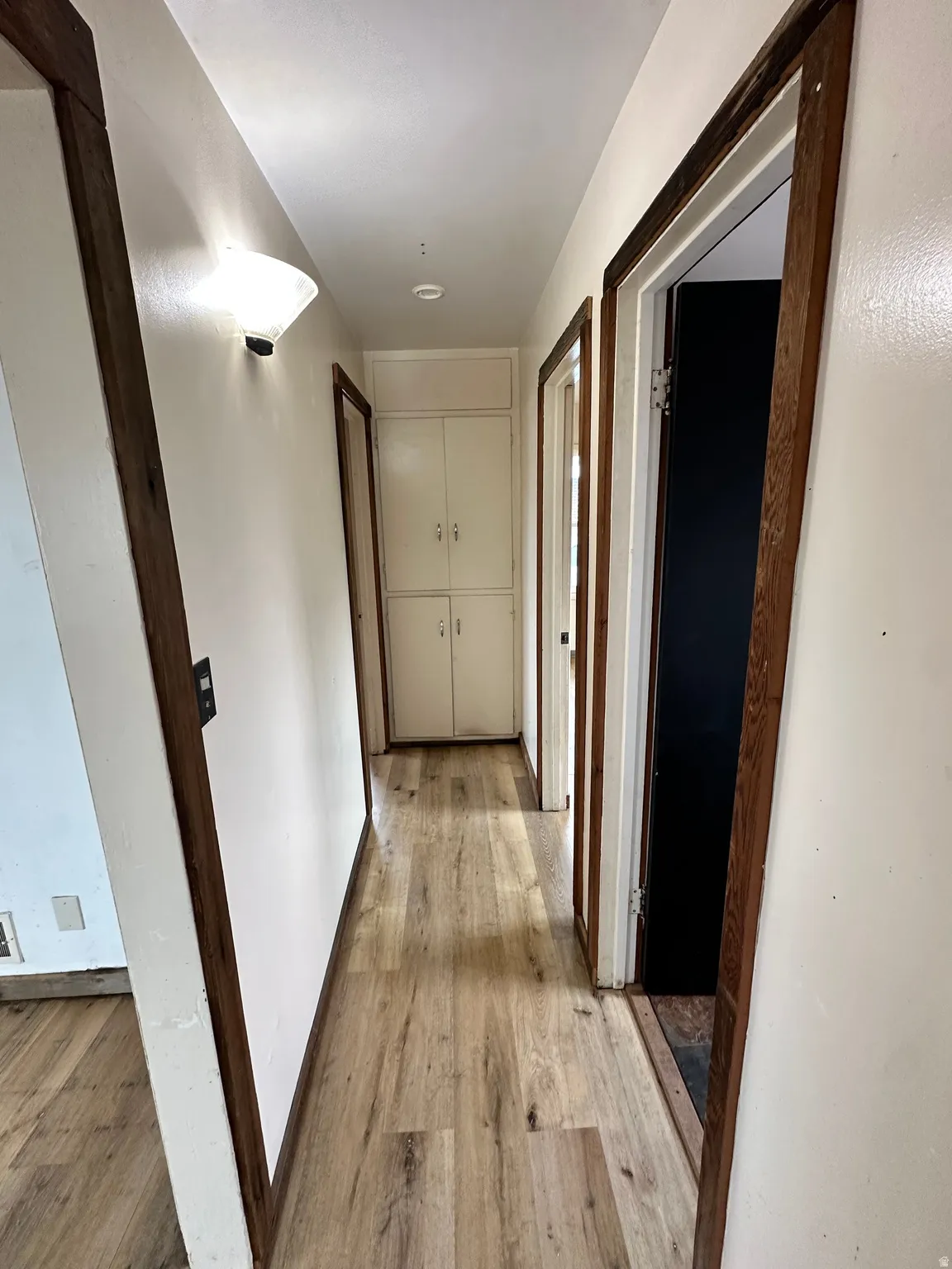 Corridor with light wood-style floors and baseboards