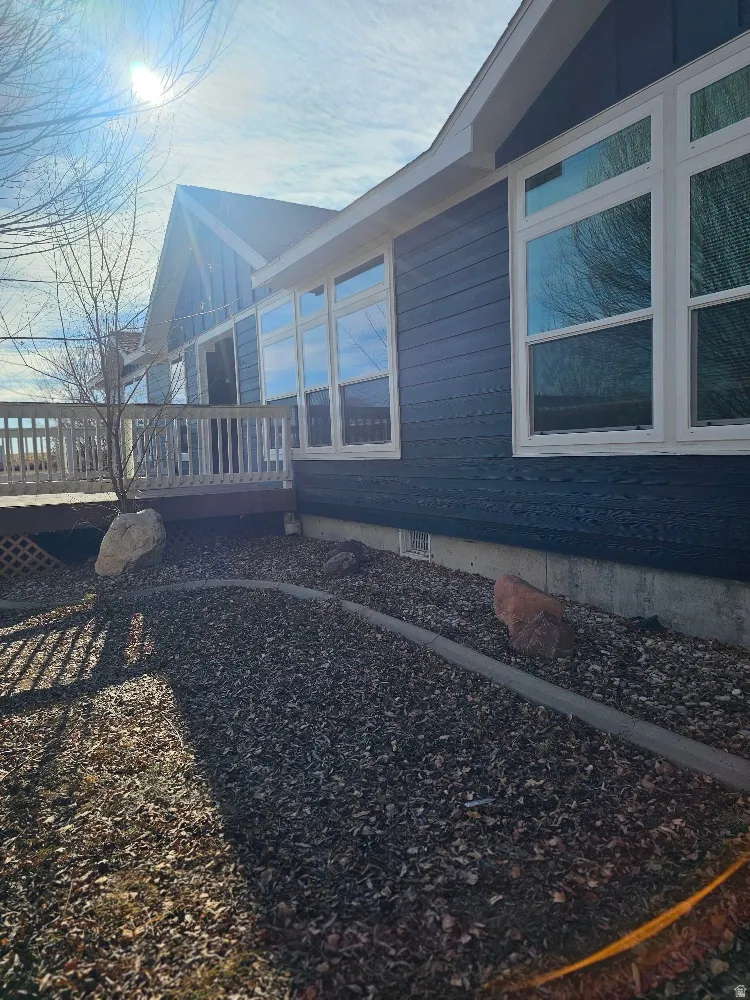 View of side of home with a wooden deck and crawl space