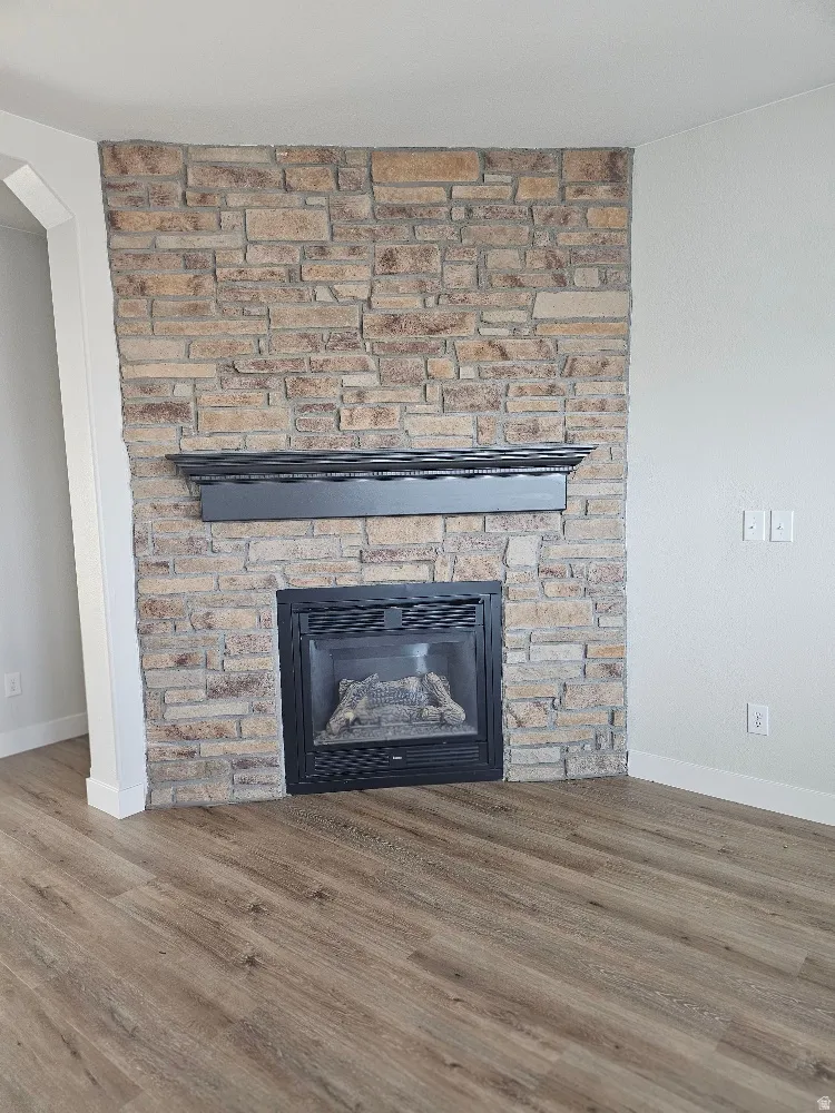 Detailed view of a stone fireplace and wood finished floors