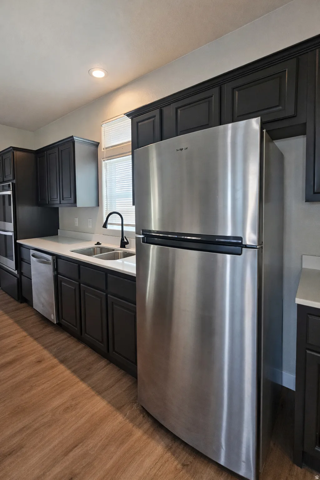 Kitchen with stainless steel appliances, dark wood finished floors, and recessed lighting