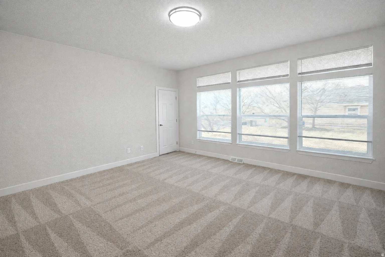 Unfurnished room featuring carpet and a textured ceiling