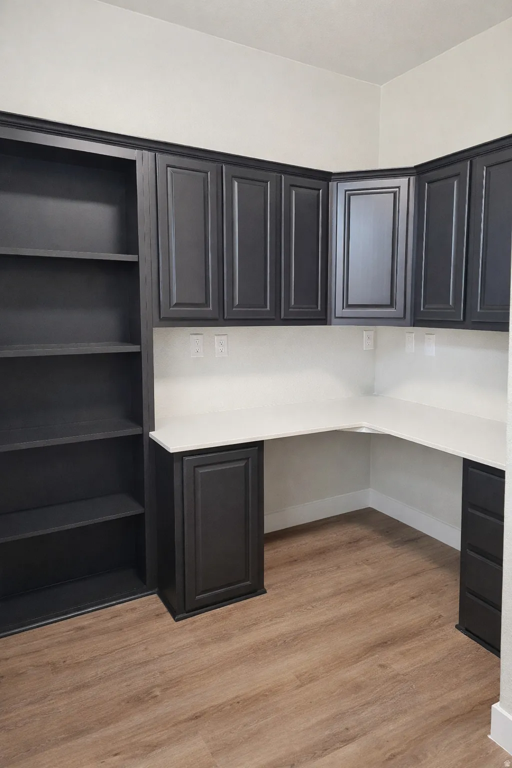 Unfurnished office featuring built in desk and light wood-style flooring