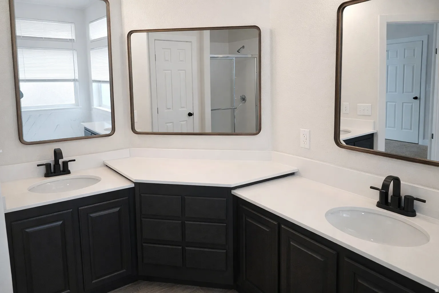 Full bath with a shower stall and two vanities