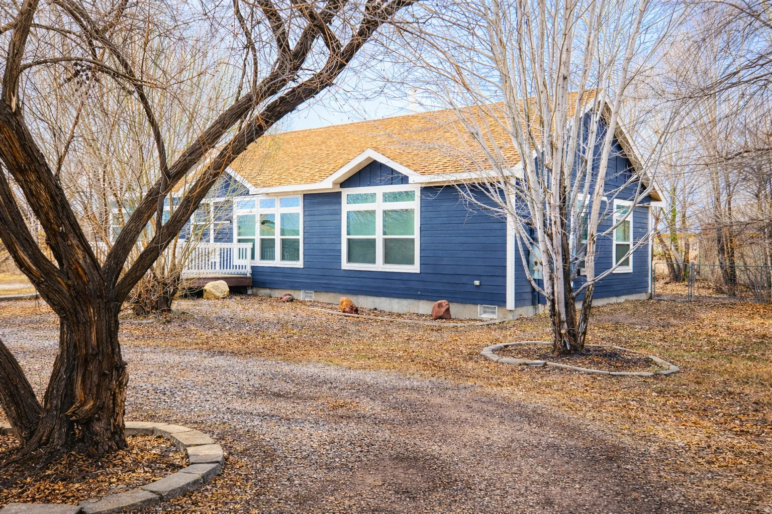 View of front of property featuring crawl space, a shingled roof, and a deck