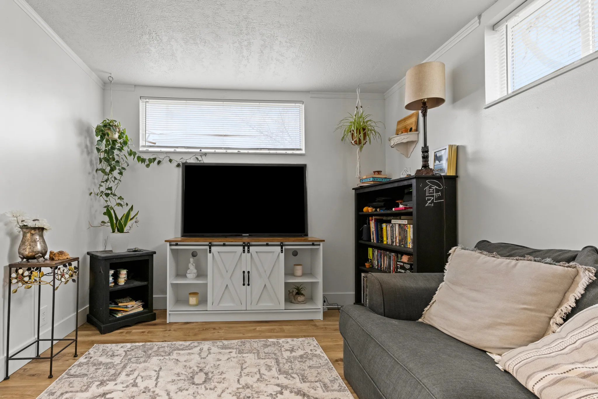 Living area featuring light wood finished floors, ornamental molding, and a textured ceiling