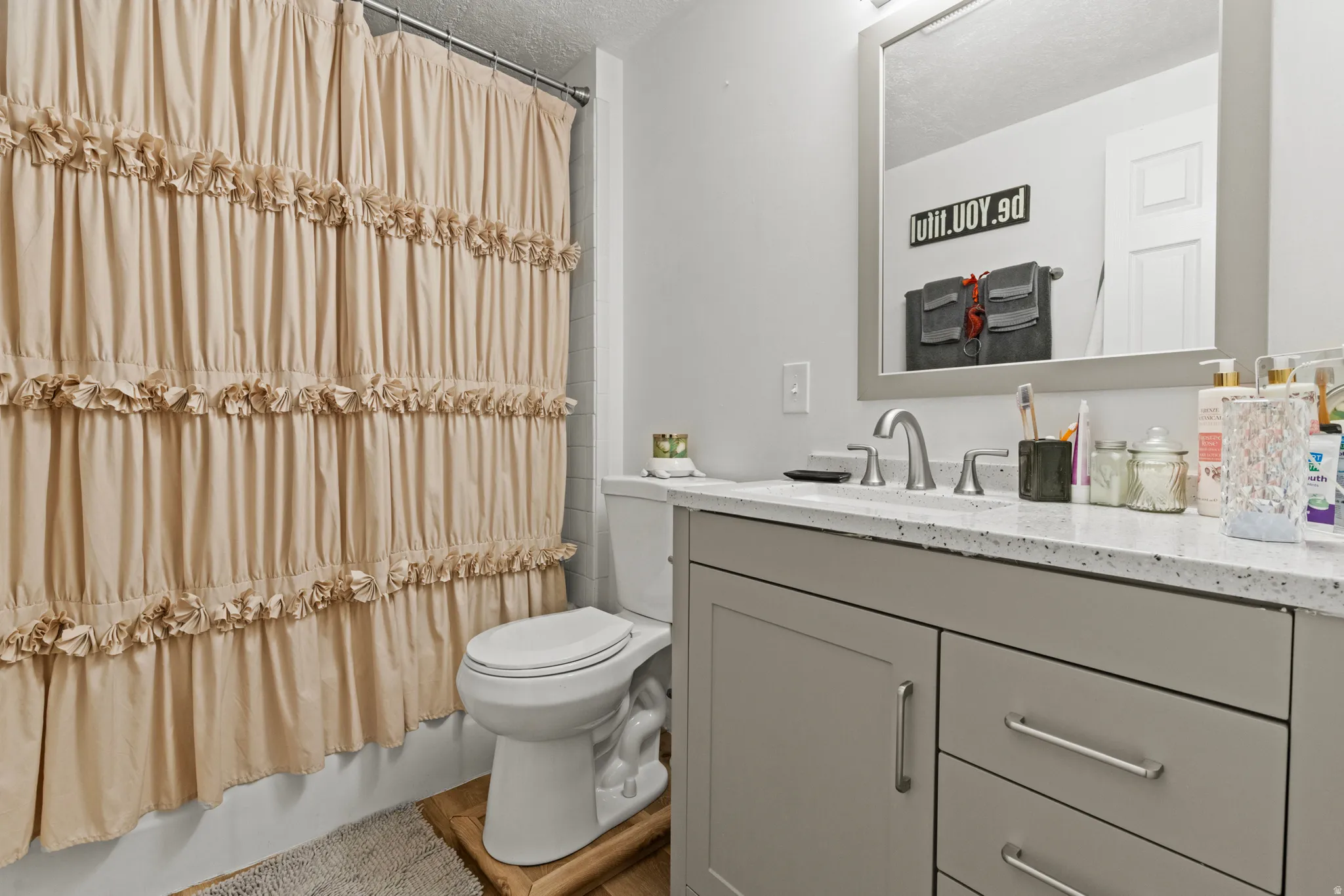 Full bath with vanity and a textured ceiling