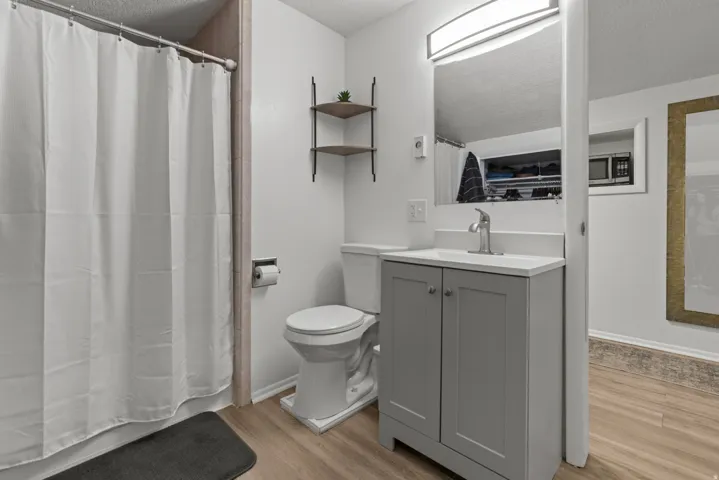 Bathroom featuring vanity, a textured ceiling, and light wood-style flooring