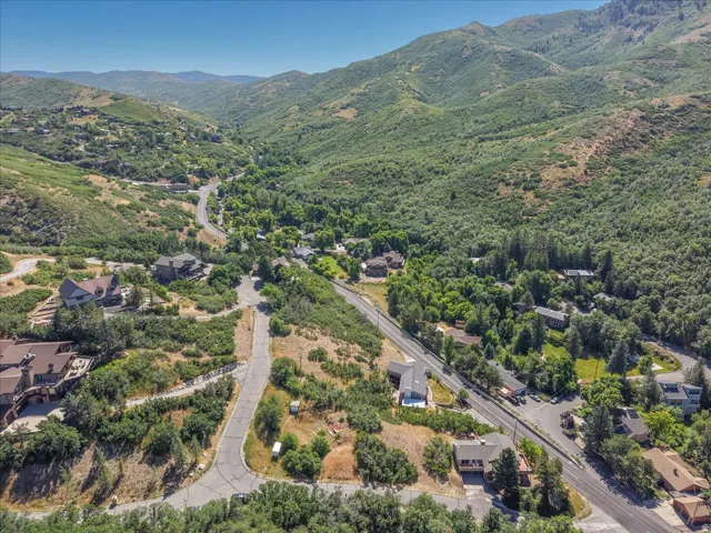 Expansive mountain valley setting with lush green foliage and scattered residential properties