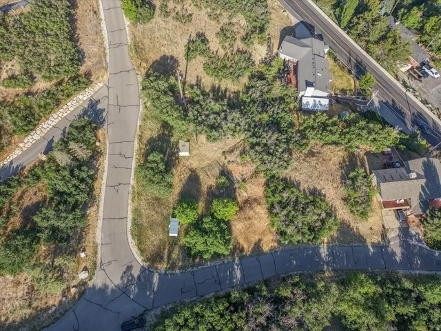 Aerial perspective featuring varied topography, established vegetation, and paved road access