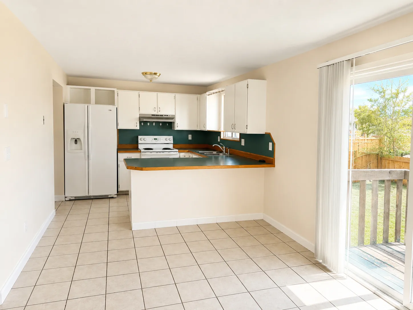 Kitchen featuring white cabinetry, dark green countertops, a built-in oven with stovetop, a side-by-side refrigerator, and tile flooring